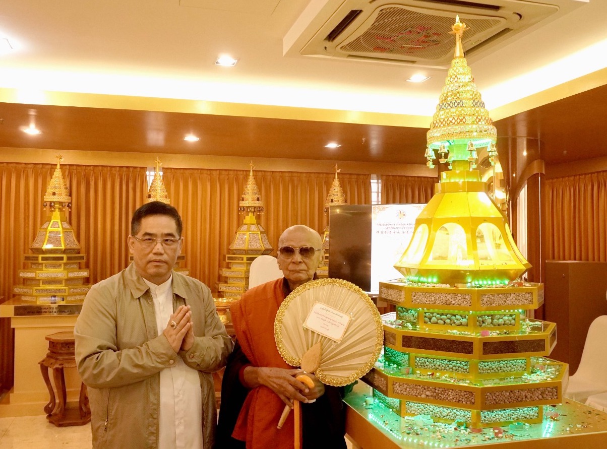 A group of men standing next to a small model of a pagoda
Description automatically generated